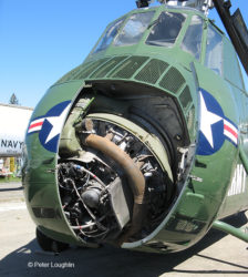 Close-up of the nose of the H-34 Choctaw helicopter. The engine compartment door is open, showing the nine-cylinder engine inside.