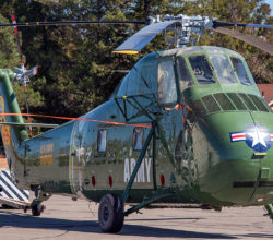 H-34 Choctaw helicopter being towed backward by a tow tractor.