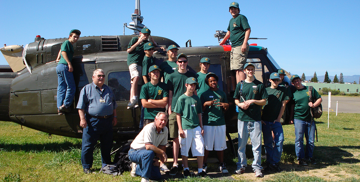 uh1h-huey-pcam-03 A group of boy scouts standing on and a the UH-1H Huey helicopter, smiling for the camera.