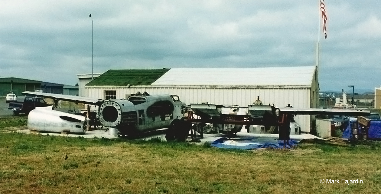 a26-invader-pcam-07 A-26 Invader seen from the rear and to the right. This is an outdoor photo of the plane in the very early stages of restoration, with the rear portion of its fuselage detached, the wings detached, no vertical fin, no engines, and many more parts missing.