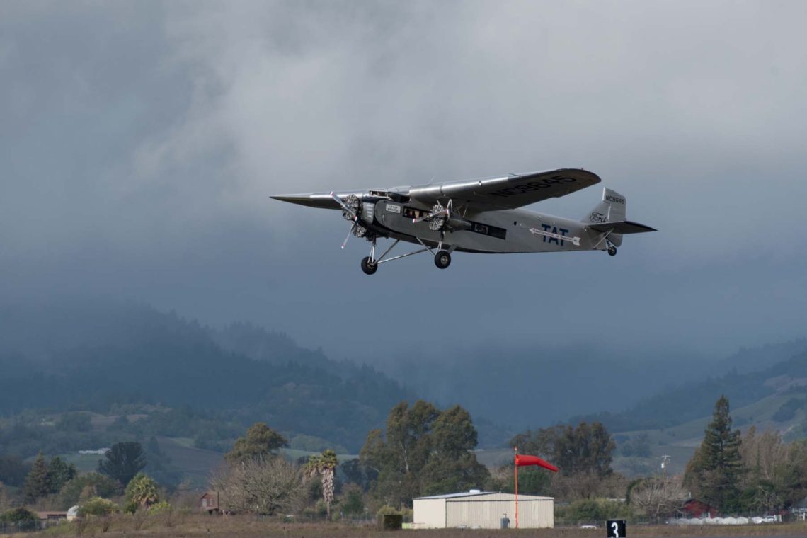 EAA 1929 Ford Tri-Motor takes off against dramatic cloudy skies