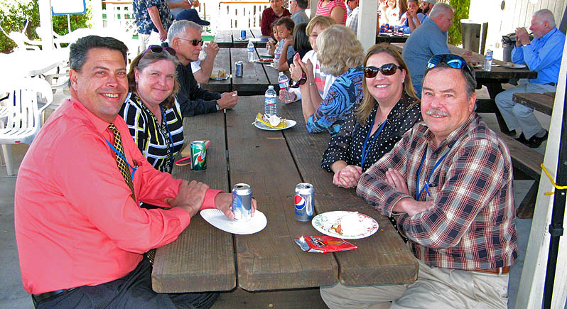 people at a picnic table enjoying lunch
