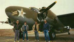 Four men standing in front of a classic WWII Lockheed bomber